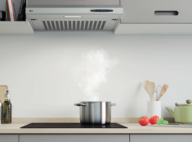 pot on the induction hob while the extractor hood sucks up the steam